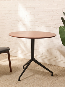 Round Walnut-Tone Pedestal Dining Table with Black Metal Base